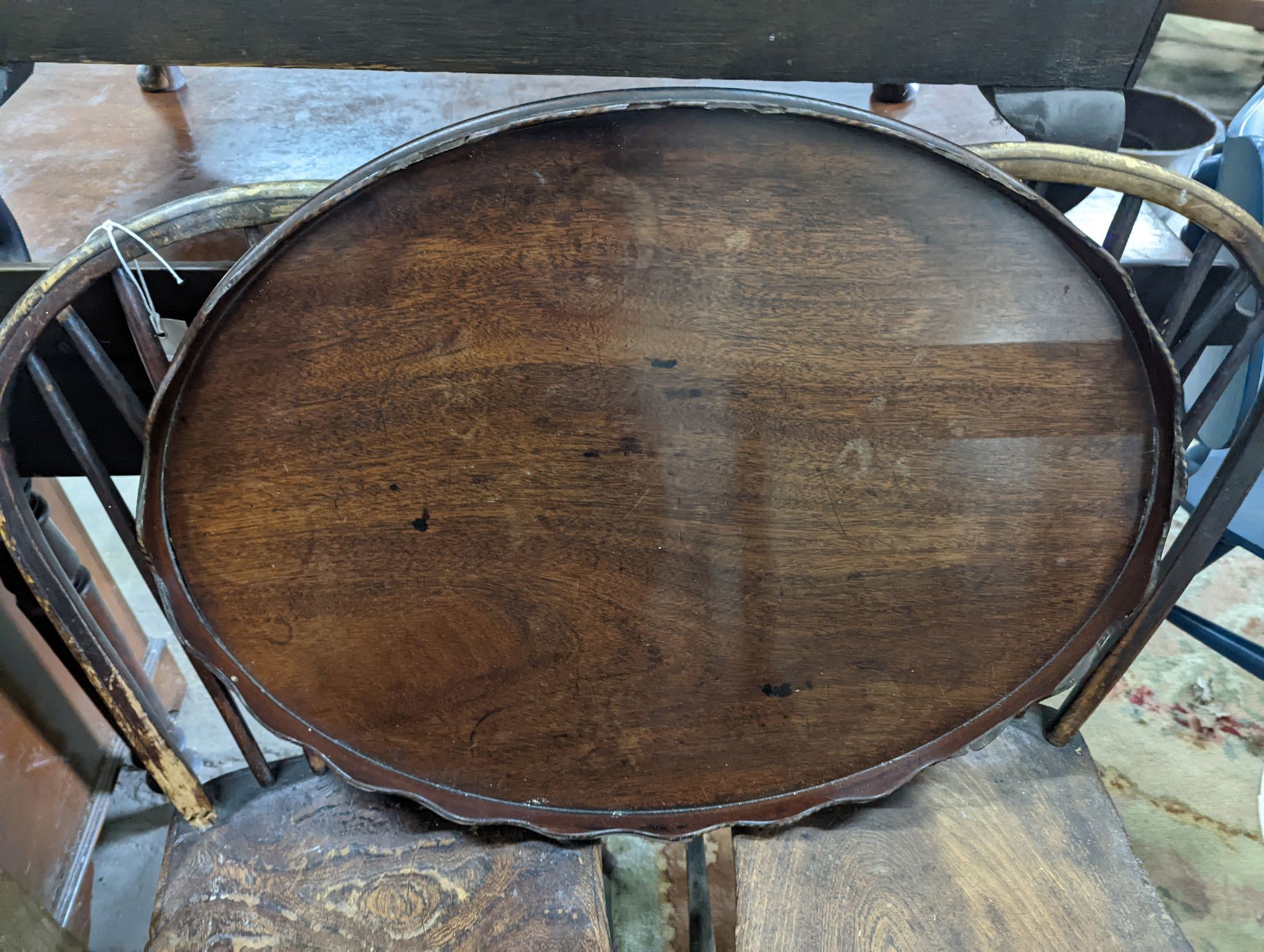 A 19th century elm and ash primitive Windsor comb back chair with traces of original paint, two other Windsor comb back chairs, a George III provincial elbow chair and an oval mahogany tea tray